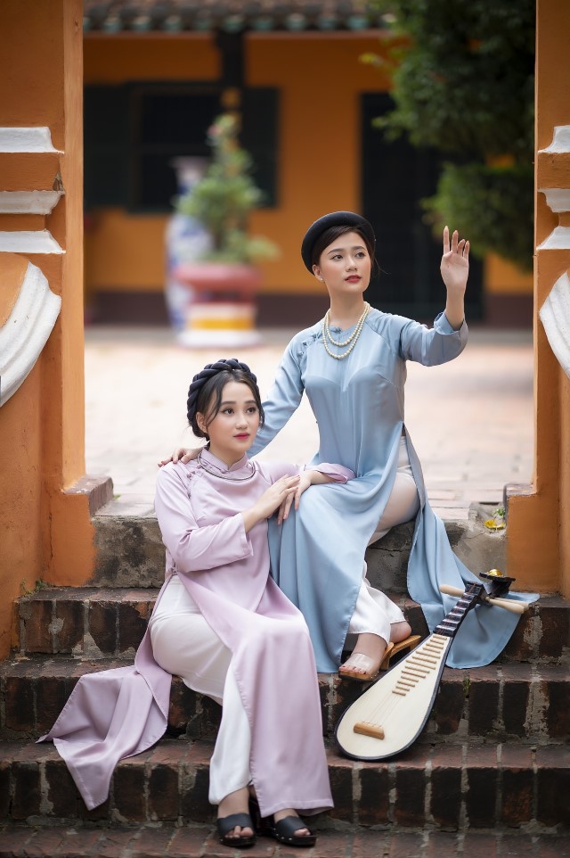 青と紫のアオザイを着たベトナム人女性